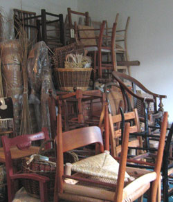 This photograph shows chairs stacked up in Sue's workshop waiting
to be worked on.